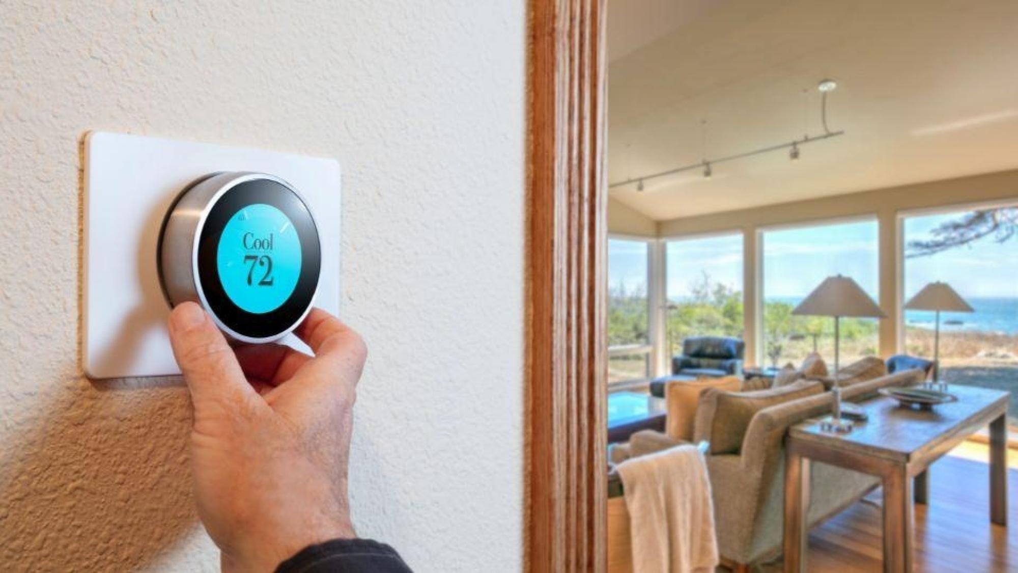 Men Adjusting A Digital Thermostat